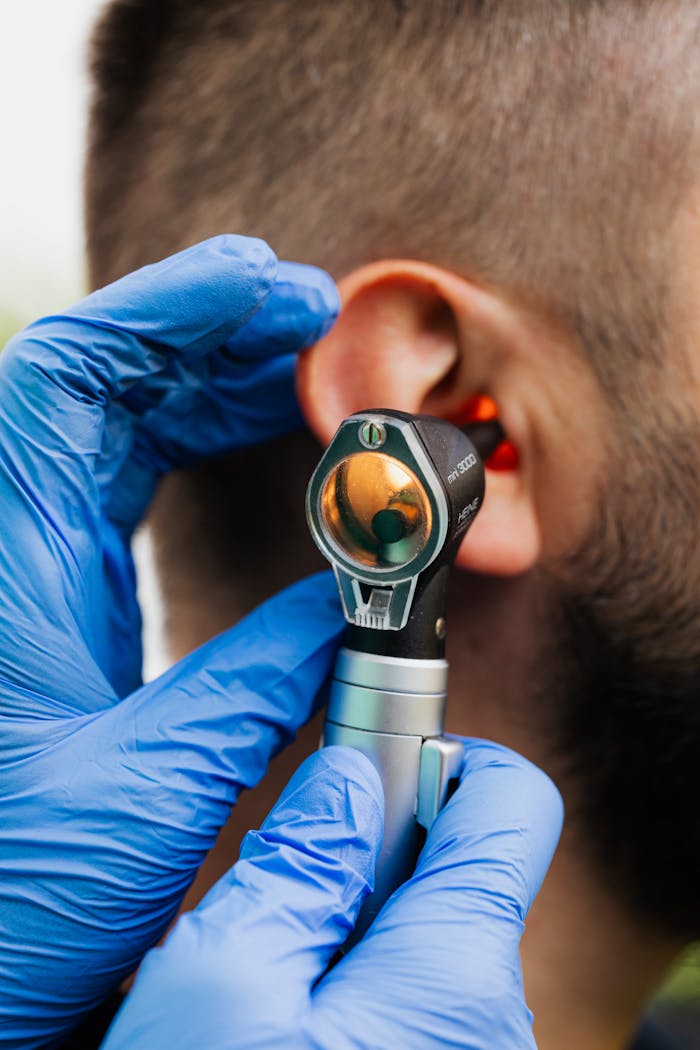 our-story Close-up of a doctor using an otoscope to examine a patient's ear.