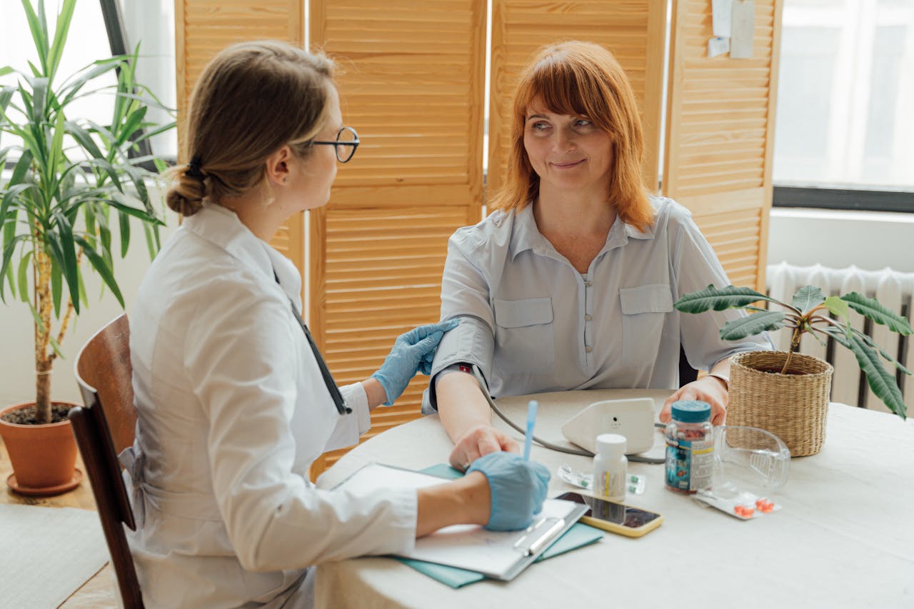 services-03 Doctor measuring patient's blood pressure with digital monitor in a clinical setting.