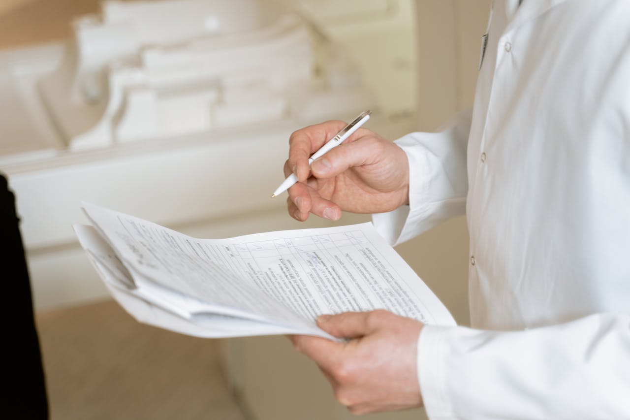 services-01 A doctor holds and reviews medical documents, demonstrating careful examination and professionalism.